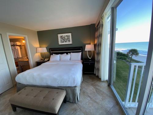 a bedroom with a large bed and a large window at Radisson Suite Hotel Oceanfront in Melbourne