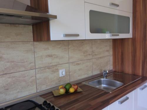 a kitchen counter with a sink and a bowl of fruit at Villa Laguna in Lumbarda