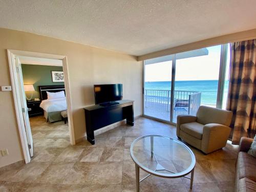 a living room with a room with a bed and a television at Radisson Suite Hotel Oceanfront in Melbourne