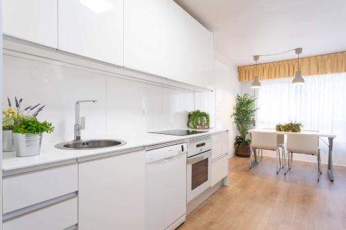 a white kitchen with a sink and a table at Sweet Home in Santa Cruz de Tenerife