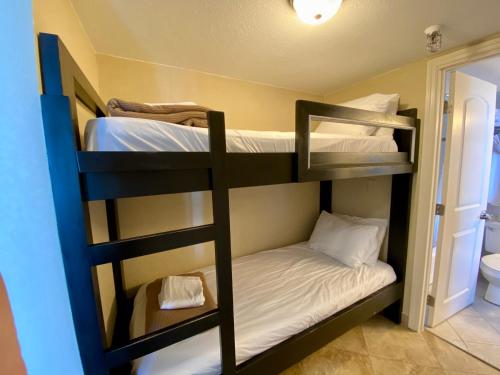 two bunk beds in a room with a bathroom at Radisson Suite Hotel Oceanfront in Melbourne