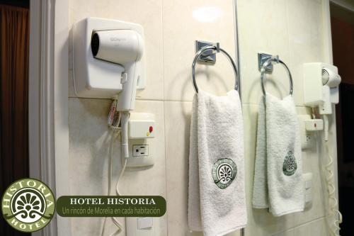 Hotel Historia في موريليا: حمام مع منشفتين معلقتين على الحائط