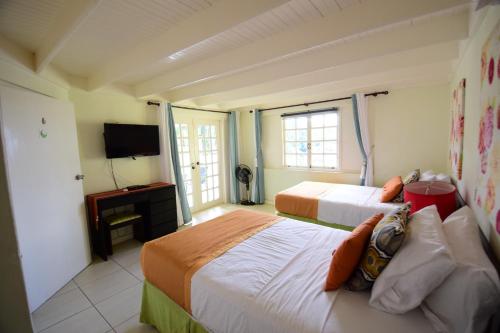 ein Hotelzimmer mit 2 Betten und einem TV in der Unterkunft The View at Mystic Ridge Penthouse 78A in Ocho Rios