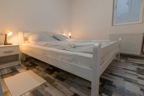 ein weißes Bett in einem Zimmer mit Fenster in der Unterkunft Apartment BB in Bajina Bašta