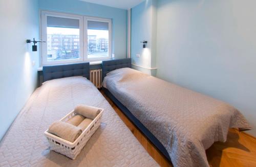 1 Schlafzimmer mit 2 Einzelbetten und einem Fenster in der Unterkunft Bielańska Apartment in Warschau