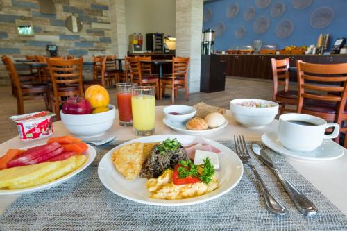 a table with plates of food and cups of coffee at Irazú Hotel & Studios in San José