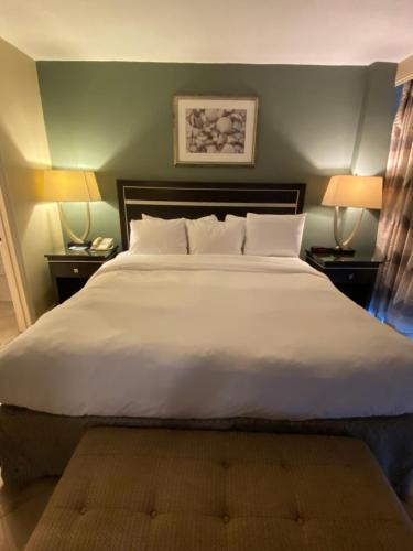 a bedroom with a large white bed with two lamps at Radisson Suite Hotel Oceanfront in Melbourne
