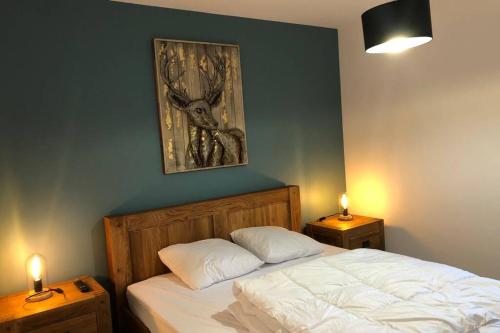 1 dormitorio con 1 cama con 2 mesitas de noche y una pintura en APPARTEMENT 8 personnes LODGES A505, en La Plagne Tarentaise