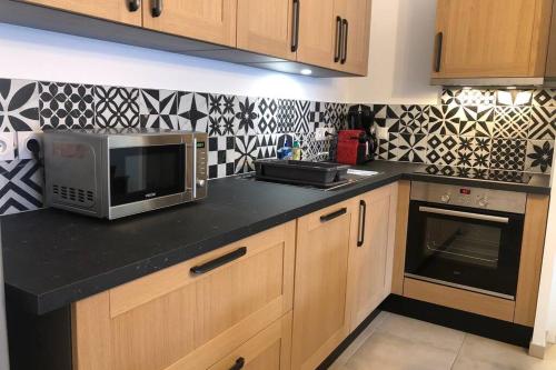 une cuisine avec un comptoir avec un micro-ondes dans l'établissement Les Cristaux de La Plagne APPARTEMENT 8 personnes LODGES A505, à La Plagne Tarentaise