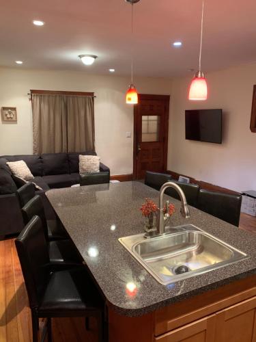a kitchen with a sink and a living room at Cozy 4 Bedroom Home Accommodates 10 in Niagara USA in Niagara Falls