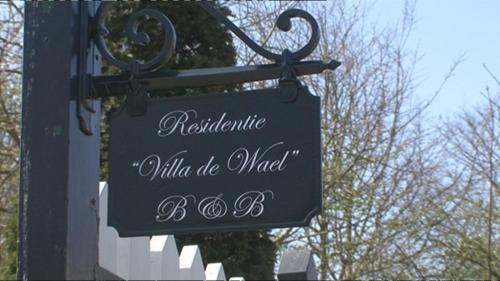ein Schild, das von einer Stange an einem Gebäude hängt in der Unterkunft Residentie Villa de Wael in Domburg