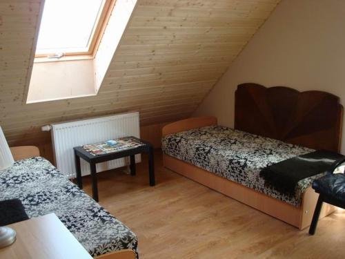 a attic room with two beds and a table at Szkoła Marzeń in Pierwoszyno