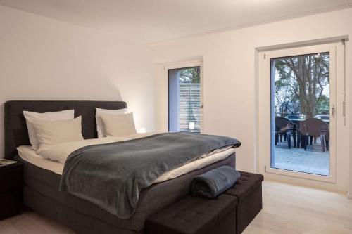 バーゼルにある2,5 Zi Design Loft Wohnung mit Gartensitzplatzのベッドルーム1室(大型ベッド1台、スライド式ガラスドア付)