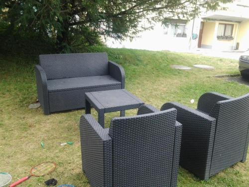 three wicker chairs and a table in a yard at Le Yanis in Lausanne