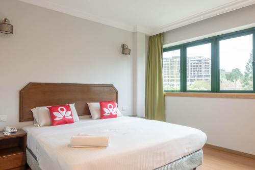a bedroom with a large bed with red pillows at Hotel Rose Crest Hill, Cameron Highland in Tanah Rata
