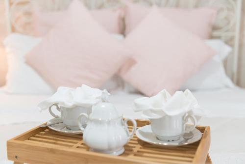 a tray with two cups and a tea set on a bed at Laetitia Guest House32 in Aversa