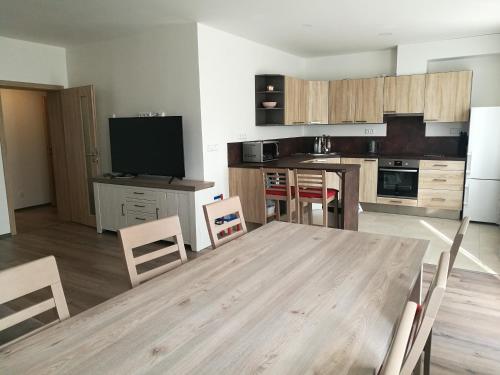 uma grande cozinha com uma mesa de madeira e cadeiras em Apartmán G4 Maty em Frymburk