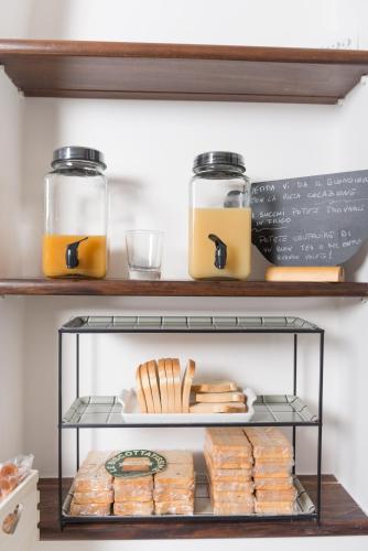 a shelf with bread and jars of honey and cheese at Laetitia Guest House32 in Aversa