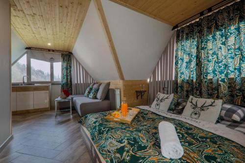 sypialnia z dużym łóżkiem i kanapą w obiekcie GÓRALSKA VILLA APARTAMENTY Z JACUZZI & HOME SPA & Zakopane w Poroninie