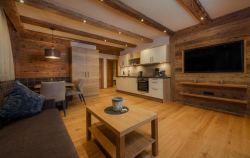 a living room with a couch and a table and a tv at NATURPARKGUT - alpdeluxe Apartments in Holzgau