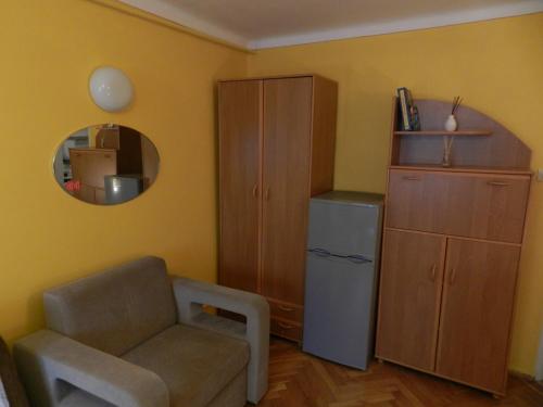 a living room with a chair and a cabinet and a mirror at Mieszkanie "Panorama" in Krynica Zdrój