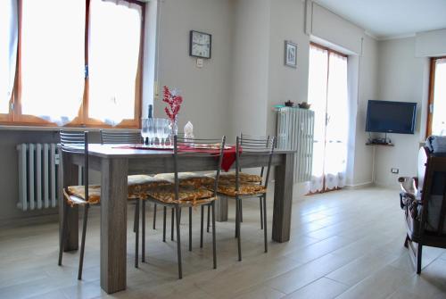 jadalnia z drewnianym stołem i krzesłami w obiekcie Il Ponte w mieście Saint Vincent