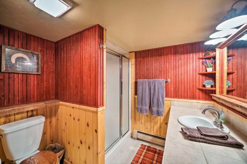a bathroom with wooden walls and a toilet and a sink at Secluded Retreat with Wood Stove, 11 Mi to Bozeman! in Gallatin Gateway