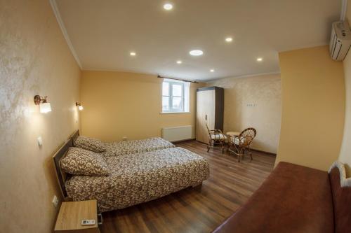 1 dormitorio con cama, sofá y mesa en Panorama Apart-Hotel, en Kamianets-Podilskyi