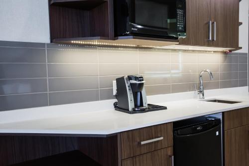 a kitchen with a coffee maker on a counter at Holiday Inn Hotel & Suites Calgary South - Conference Ctr by IHG in Calgary