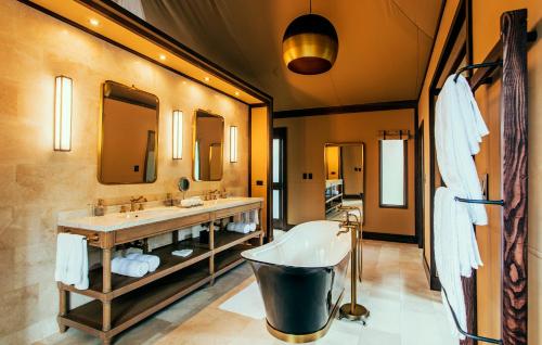 a bathroom with two sinks and a bath tub at Nayara Tented Camp in Fortuna