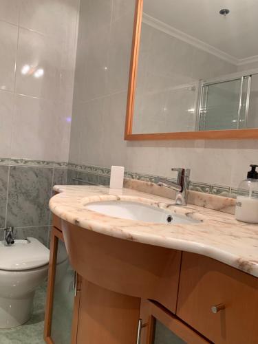 a bathroom with a sink and a toilet and a mirror at Oktheway San Eufrasio in Sarria