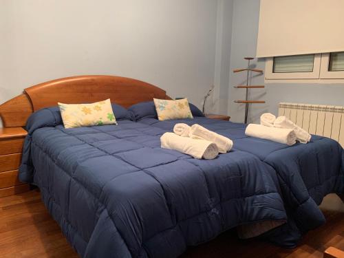 a blue bed with towels on top of it at Oktheway San Eufrasio in Sarria