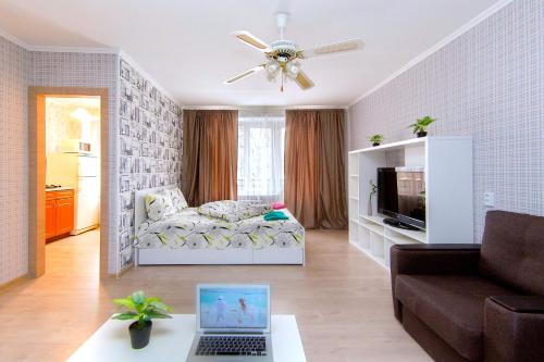 a living room with a couch and a laptop on a table at HotelRoom24 on Belorusskaia in Moscow