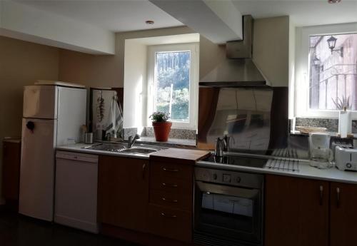 uma cozinha com um frigorífico branco e um lavatório em Casa acogedora con vistas al mar em Valdoviño