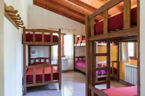 a room with three bunk beds in a house at Hostel El Mirador in El Bolsón
