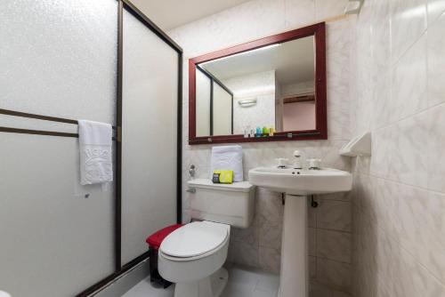a bathroom with a toilet and a sink and a mirror at Ayenda 1408 Jaba Santiago de Cali in Cali
