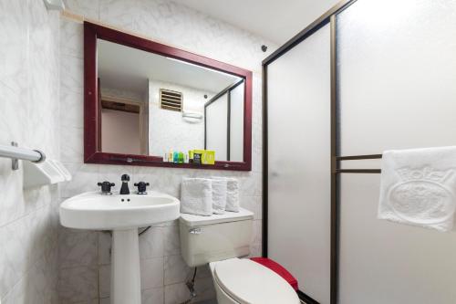 a bathroom with a sink and a toilet and a mirror at Ayenda 1408 Jaba Santiago de Cali in Cali