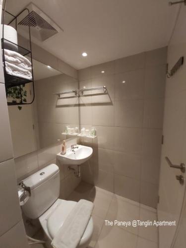 a bathroom with a toilet and a sink at The Paneya @Tanglin Apartment in Surabaya