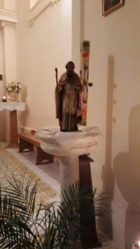 a statue of a man sitting on a table in a room at Emidio House in Termini