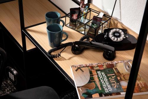a desk with a phone and a magazine at Maison 46 in Paris
