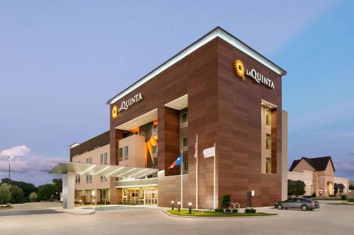a building with a car parked in a parking lot at La Quinta Inn & Suites by Wyndham College Station North in College Station