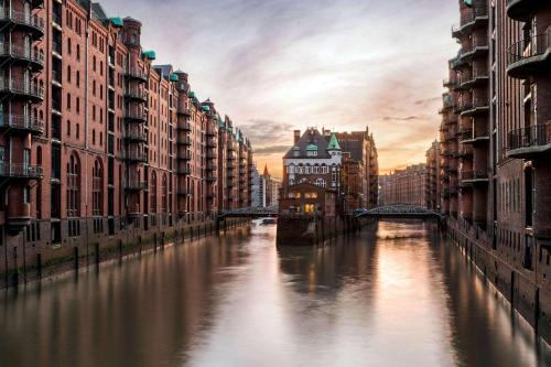 a river in a city with buildings and a bridge at Super 8 by Wyndham Hamburg Mitte in Hamburg