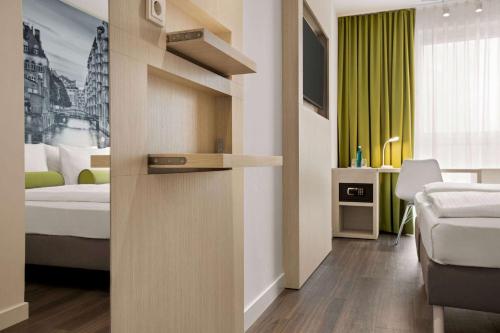 a bedroom with a bed and a dresser at Super 8 by Wyndham Hamburg Mitte in Hamburg