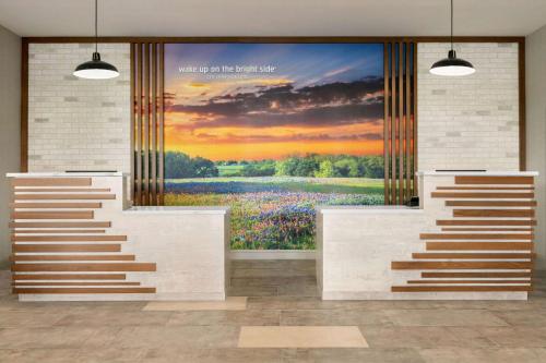 a large painting of a field of flowers on a wall at La Quinta Inn & Suites by Wyndham College Station North in College Station