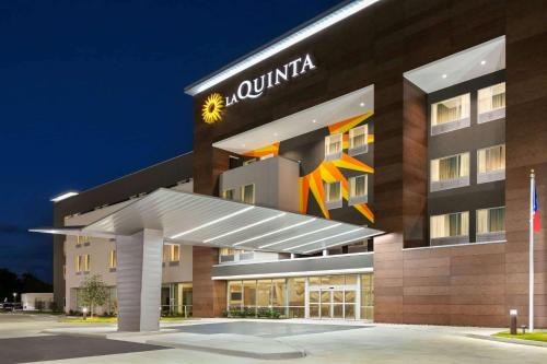 ein Hotelgebäude mit einem Schild darauf in der Unterkunft La Quinta Inn & Suites by Wyndham College Station North in College Station