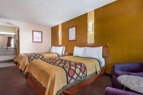 a hotel room with two beds and a chair at Super 8 by Wyndham Waco/Mall area TX in Waco