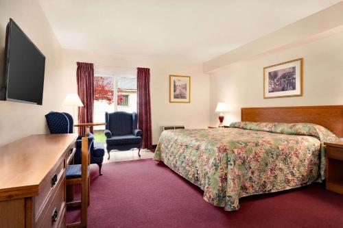 Cette chambre comprend un lit et un bureau. dans l'établissement Travelodge by Wyndham Port Elgin, à Port Elgin
