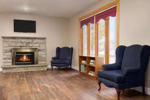 a living room with two chairs and a fireplace at Travelodge by Wyndham Port Elgin in Port Elgin
