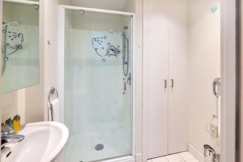 a bathroom with a shower and a sink at Cityscape Charm Apt w Parking, Views, Pool & Gym in Auckland