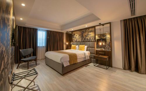 a hotel room with a bed and a chair at Almond Business Hotel in Nicosia